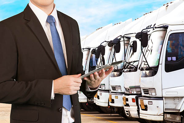 fleet management services manager in front of a fleet of trucks
